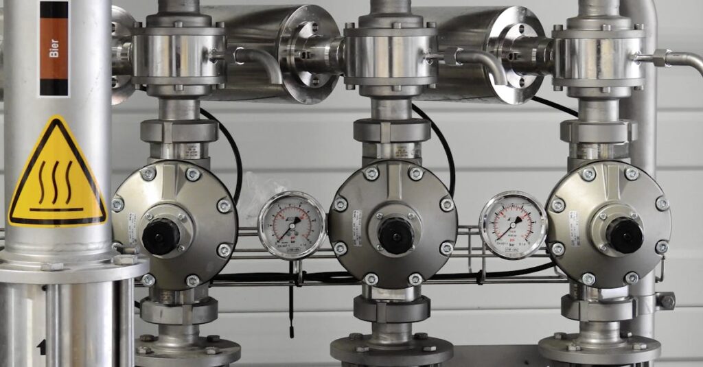 Close-up of stainless steel pipes with pressure gauges in an industrial setting.